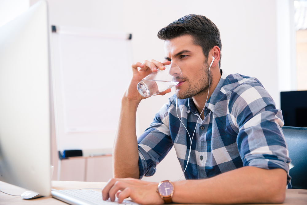Man in a flannel typing on a computer.